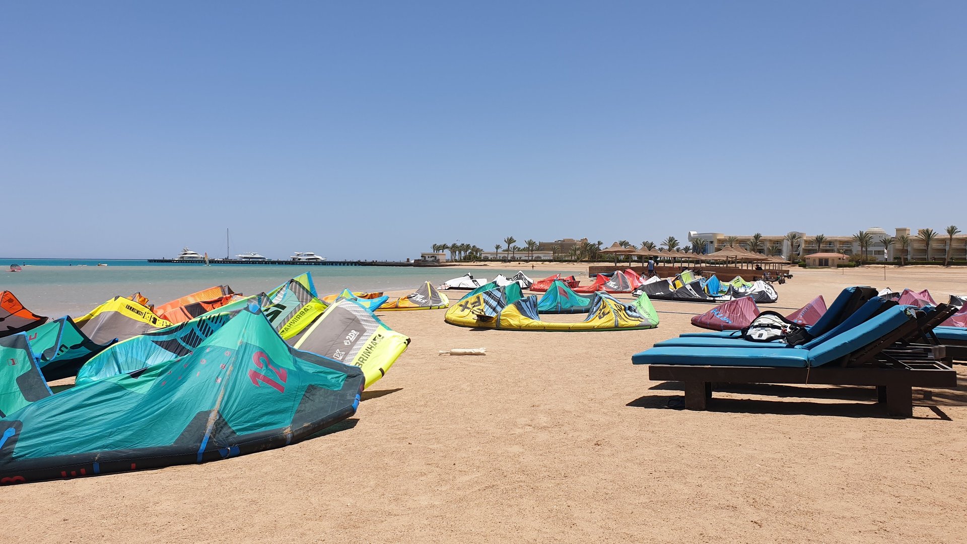 Many colorful Kites laying in the sand of Soma bay