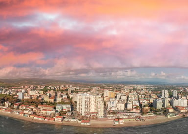 Follonica Kitesurfing in Toscany aerial view of the beach with some high buildings and cheesy purple light at sundown