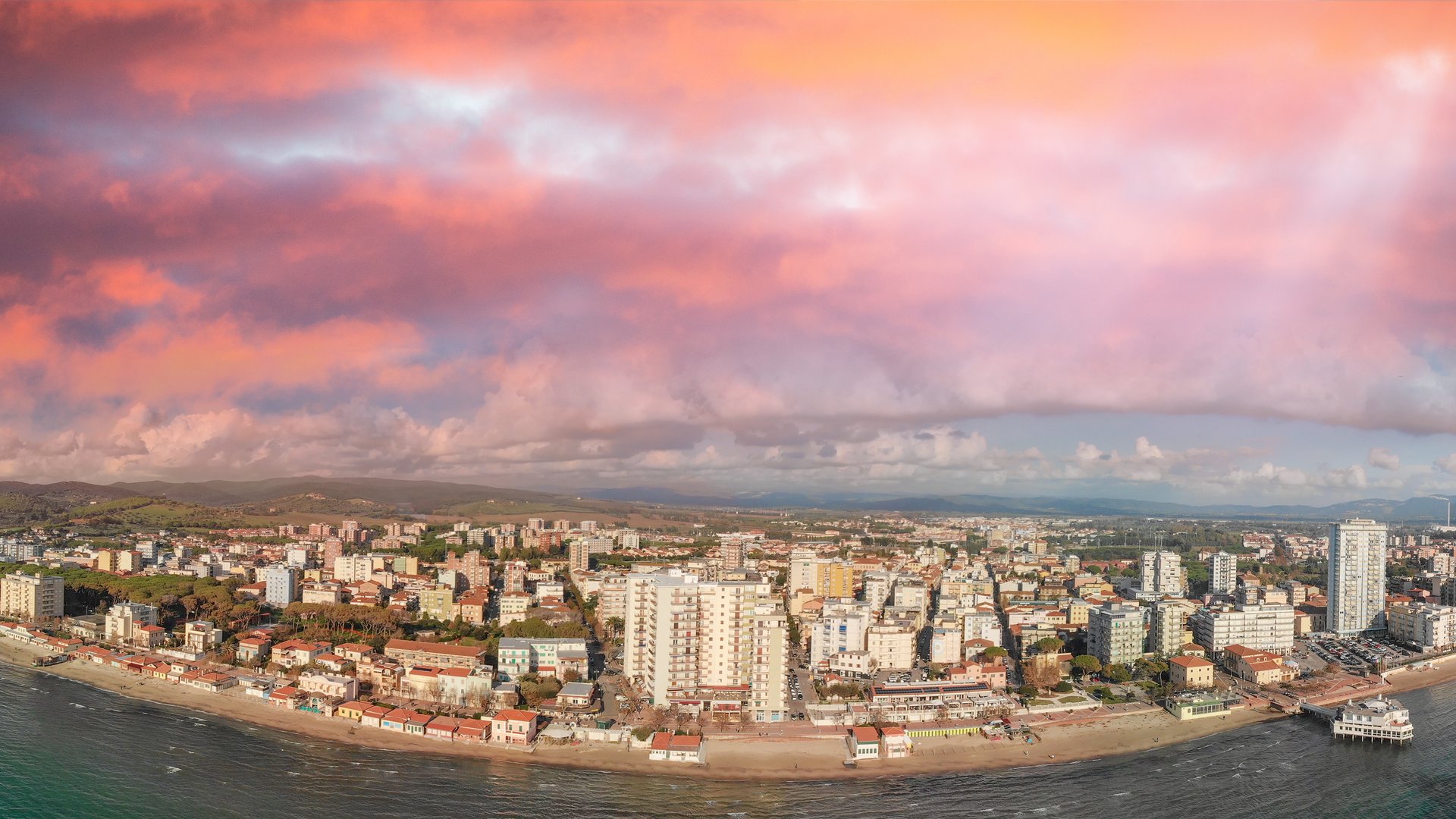 Follonica Kitesurfing in Toscany aerial view of the beach with some high buildings and cheesy purple light at sundown