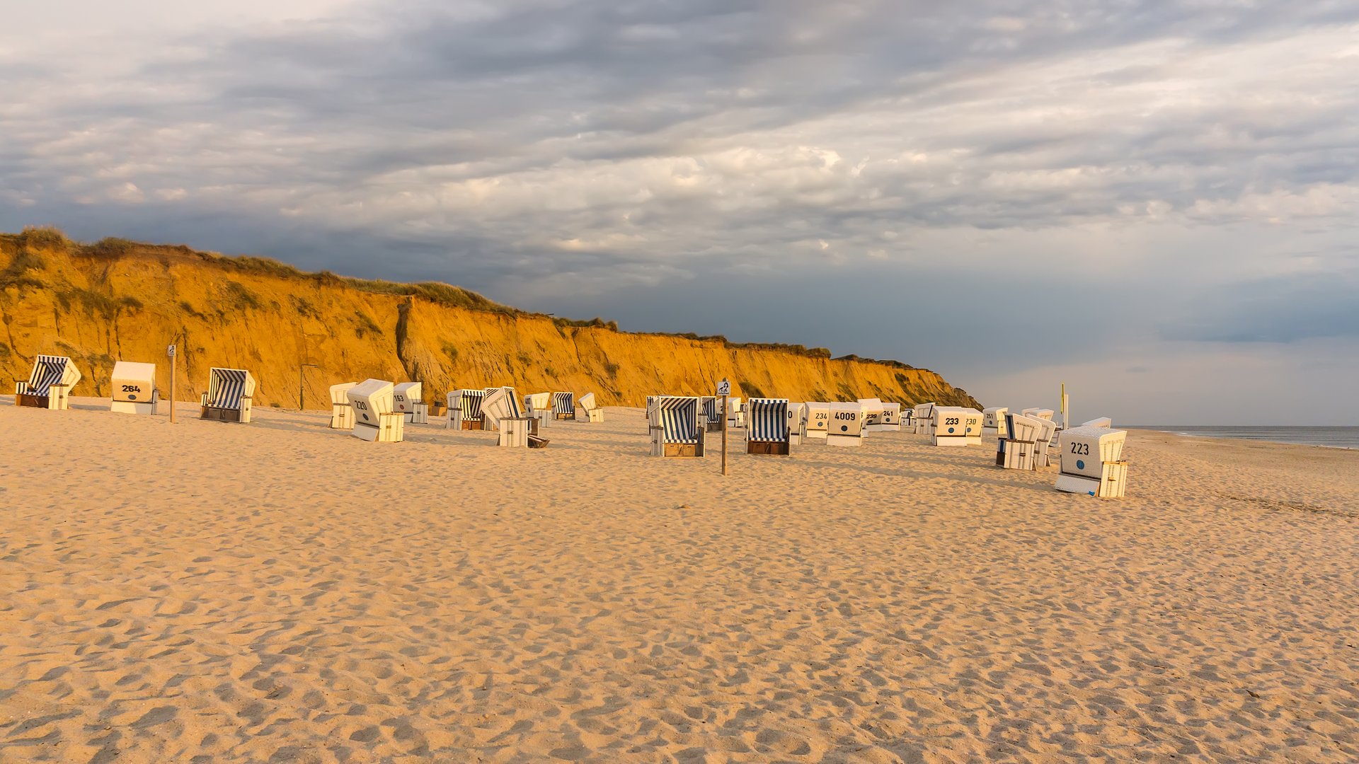 Kampen Kitesurfing Sylt with Beach Chairs in the sand with stony mountain in the background