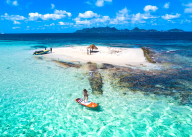 Stand Up Paddler enjoying crystal clear water in front of Morpion Island in Saint Vincent and the Grenadines