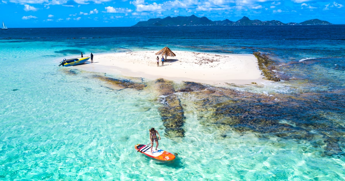 Stand Up Paddler enjoying crystal clear water in front of Morpion Island in Saint Vincent and the Grenadines