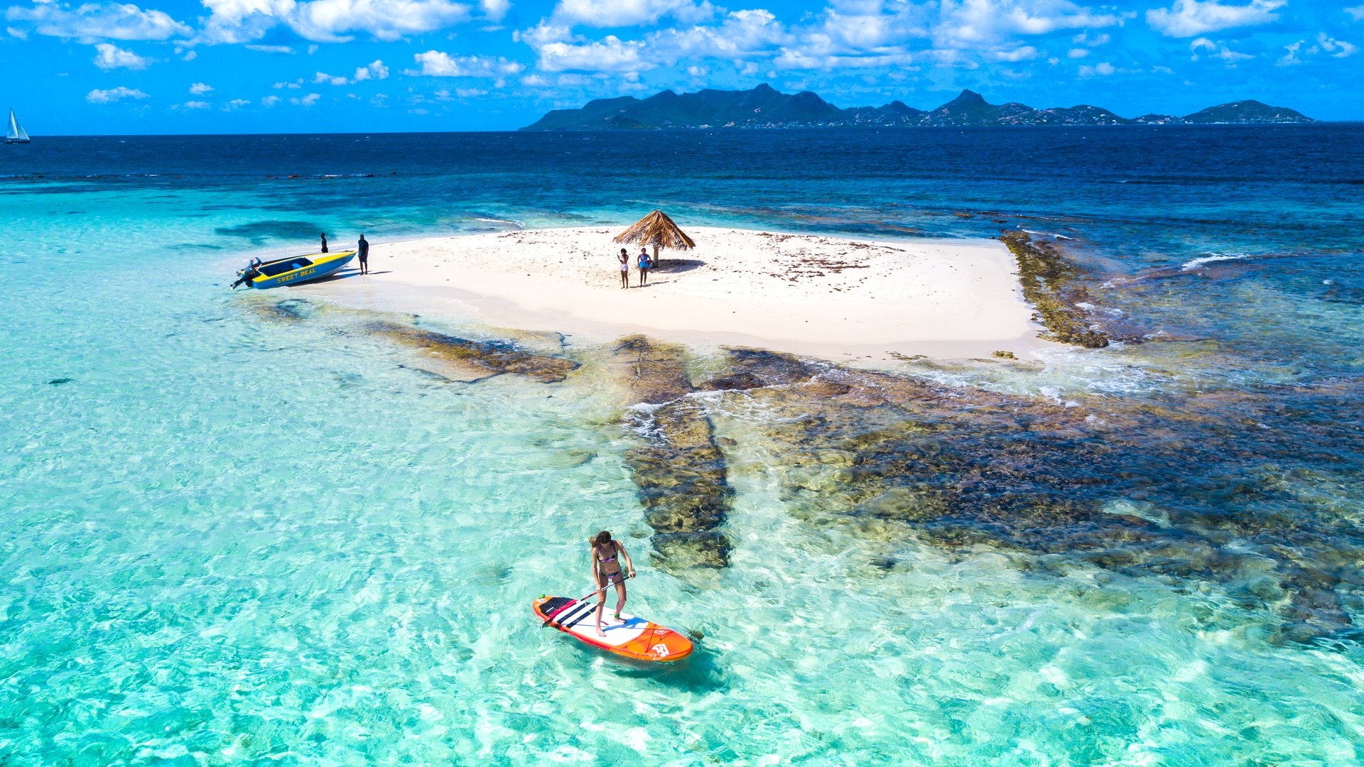 Stand Up Paddler enjoying crystal clear water in front of Morpion Island in Saint Vincent and the Grenadines