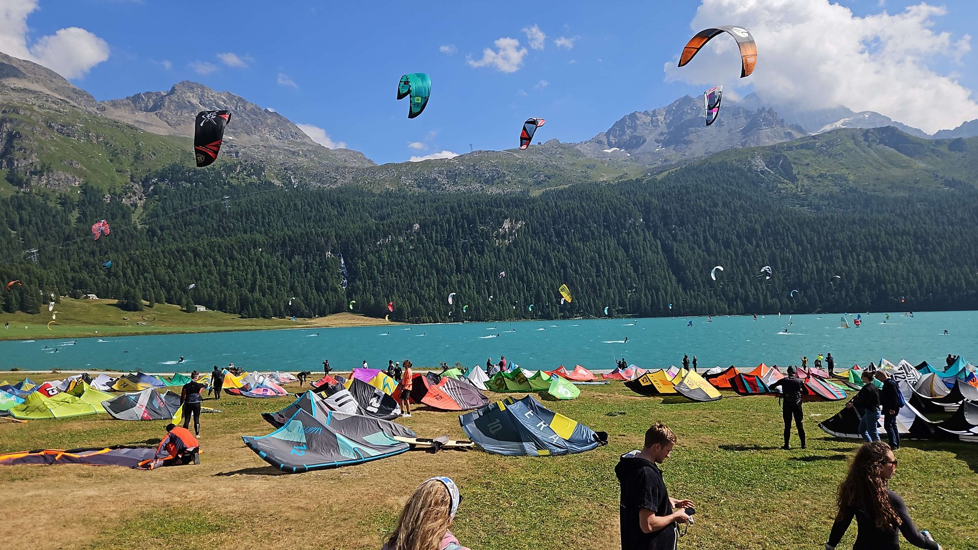 Kites lying on green grass at lake Silvaplane