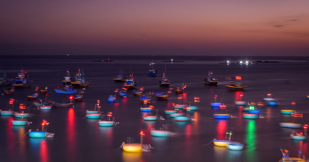 Colorful little boats lighted up in the evening in Mui Ne