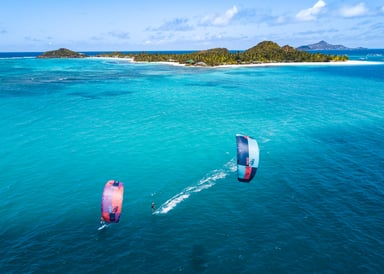2 kitesurfers having a kite session in front of Palm Island in Saint Vincent and the Grenadines