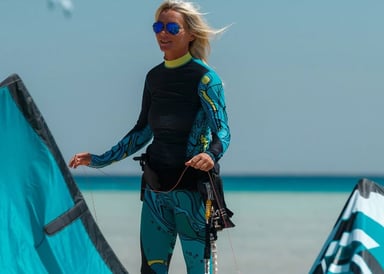 Sigri Kitesurfing in Lesbos Greece image of a closeup shot of a woman holding her turqoise kite smiling on the beach