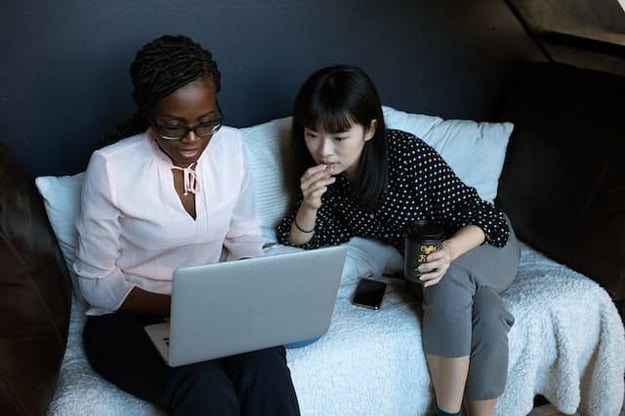 two woman looking at a computer