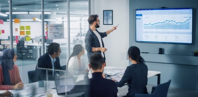 Business professionals gathered in the conference room to discuss their nearshoring progress results.