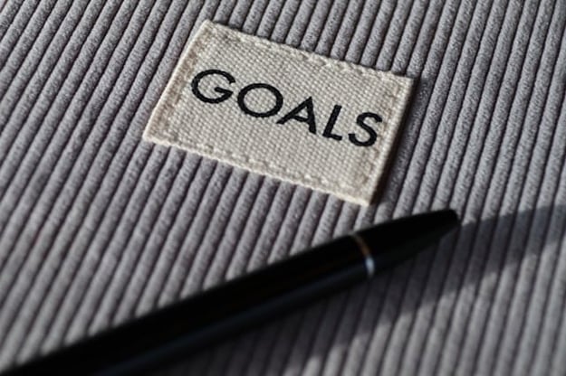 Close-up of the word Goals on gray fabric and a  pen next to it