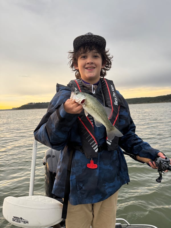 Young angler proudly displaying a bass while fishing