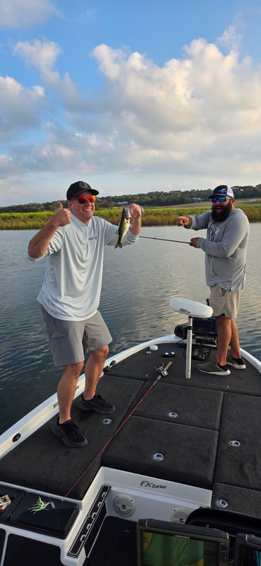 Two anglers on a boat celebrating a fish catch during a tournament.