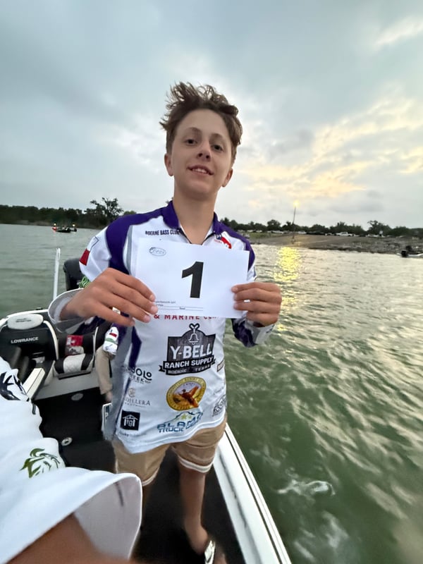 Participant holding a first place sign at the fishing tournament