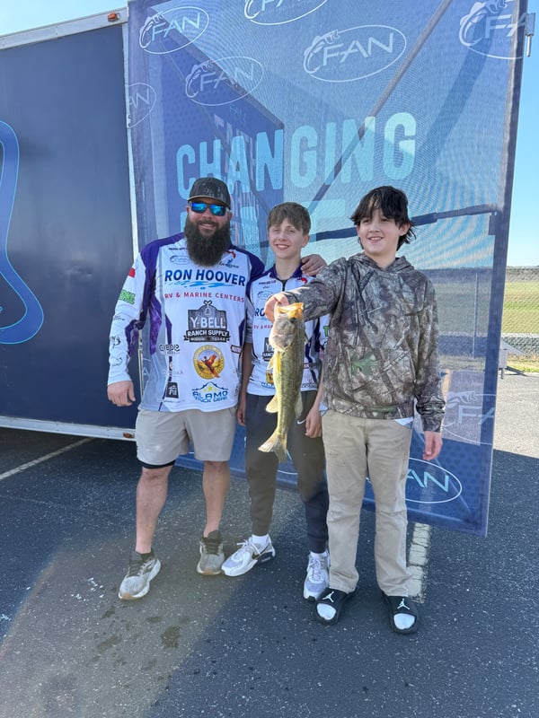 Two youth anglers posing with a caught fish during a tournament