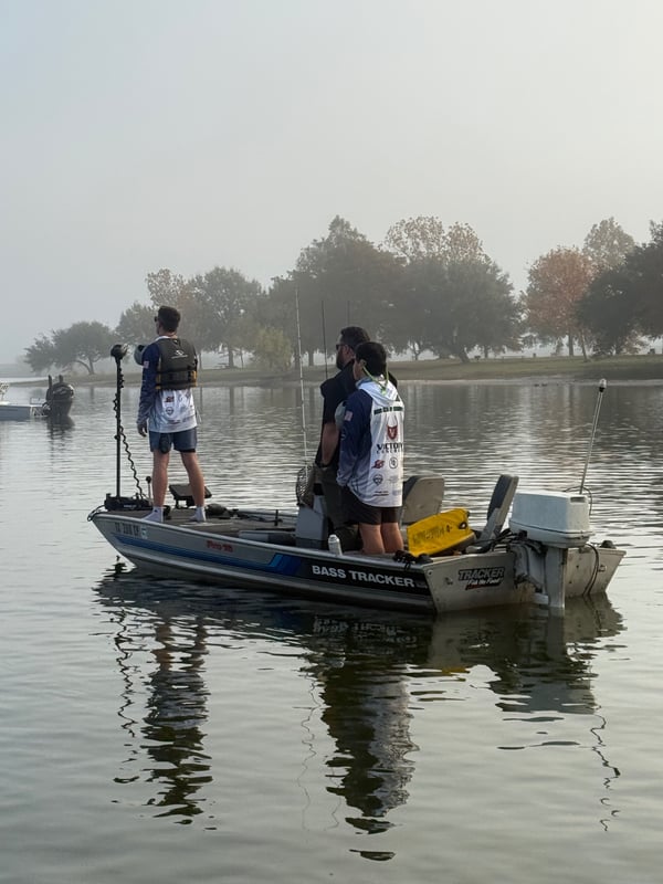Anglers on a bass boat fishing in foggy conditions