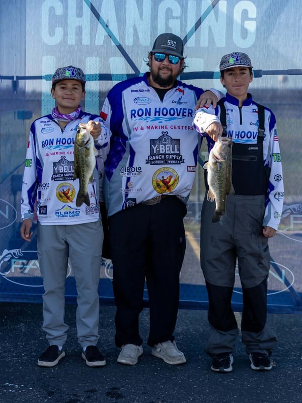 Two youth anglers and an adult with their caught bass