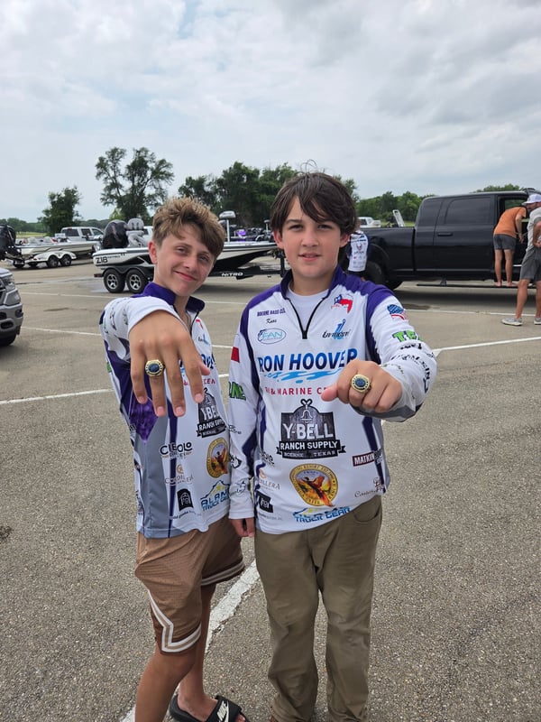 Two young anglers proudly displaying their tournament rings.