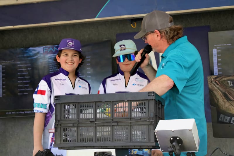 Smiling youth anglers at a fishing tournament presentation.