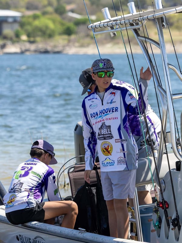Two young anglers on a fishing boat getting ready for a tournament.