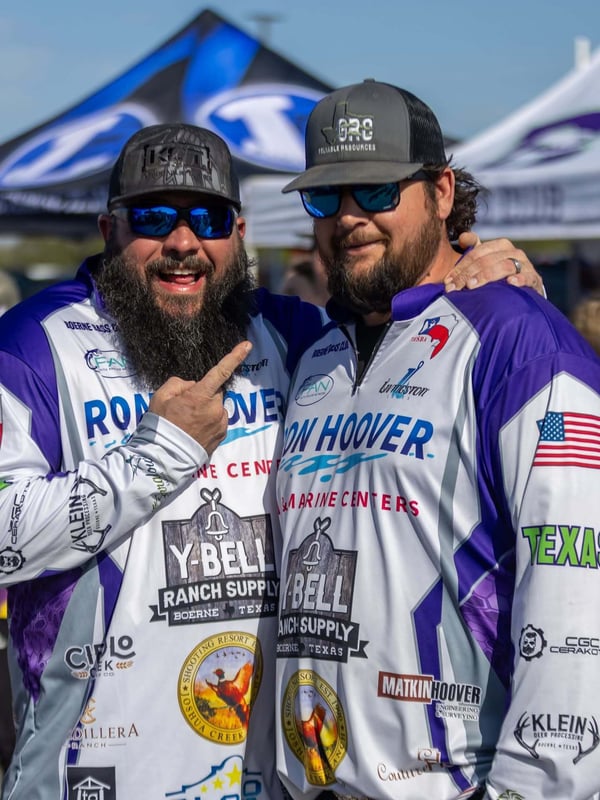 Two participants pose at a bass fishing tournament.