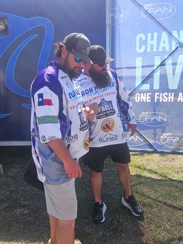 Two fishermen discussing strategies at a bass fishing tournament