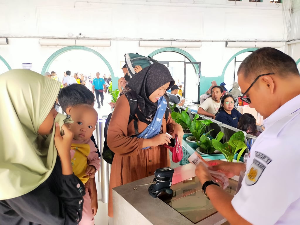 Suasana penumpang saat melakukan boarding pass di Stasiun Pasarsenen