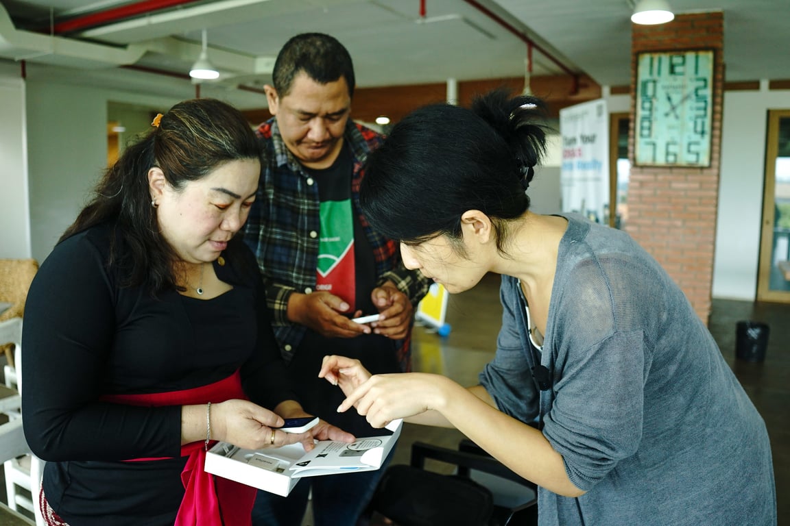 Xi Chen demonstrates the Pocketalk AI translation device to attendees.