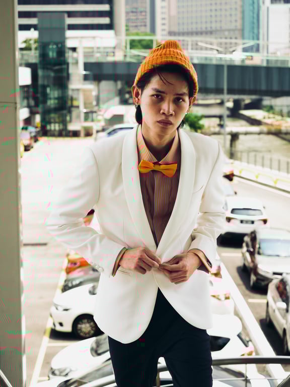Eclectic and elegantly composed, this ivory shawl-lapel tuxedo meets its match in sleek black tuxedo pants, accented by a pencil-striped dress shirt in vibrant tangerine. 