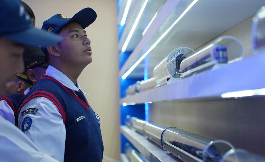 Salah satu siswa SMP N 3 Ngamprah sedang melihat miniatur rangkaian gerbong kereta buatan CRRC Sifang dalam kunjungan “CRRC Green Speed Exchange Center” di Depo Kereta Cepat Tegalluar