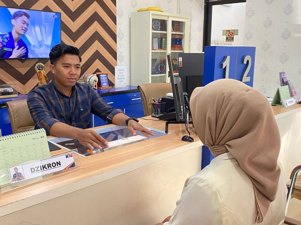Foto: Petugas di stasiun sedang melayani proses registrasi tarif diskon khusus untuk pelanggan.
