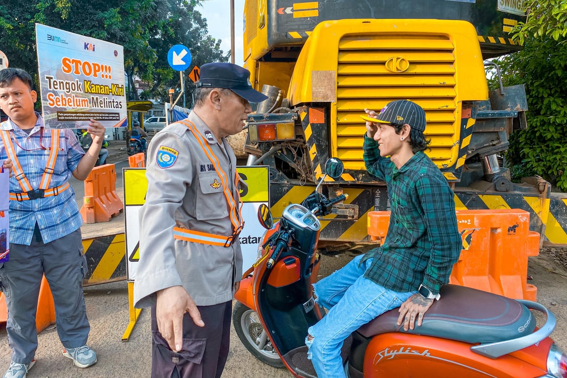 Petugas Kepolisian memberikan peringatan kepada pengendara yang nekat melintasi jalur KA, pada Sabtu (21/6), di JPL 40 wilayah Stasiun Kramat.