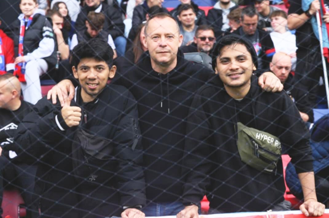 Firly dan Qadri, PMI dari Gapai sedang menonton pertandingan sepak bola bersama rekan kerja