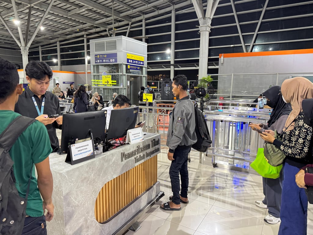 petugas boarding melakukan pencocokan data identitas pelanggan saat boarding di Stasiun Jatinegara, Selasa (1/7)