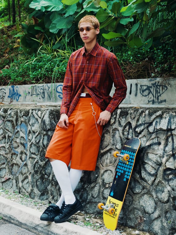 Fearless and brimming with energy, this look combines a red-orange plaid casual button-up with effortlessly stylish shorts. It's a vibrant expression of freedom and movement.