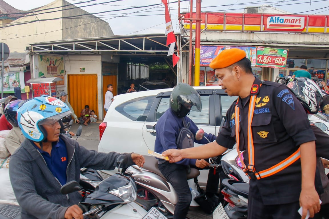 Petugas Polsuska saat Membagikan Stiker Imbauan kepada Pengguna Jalan