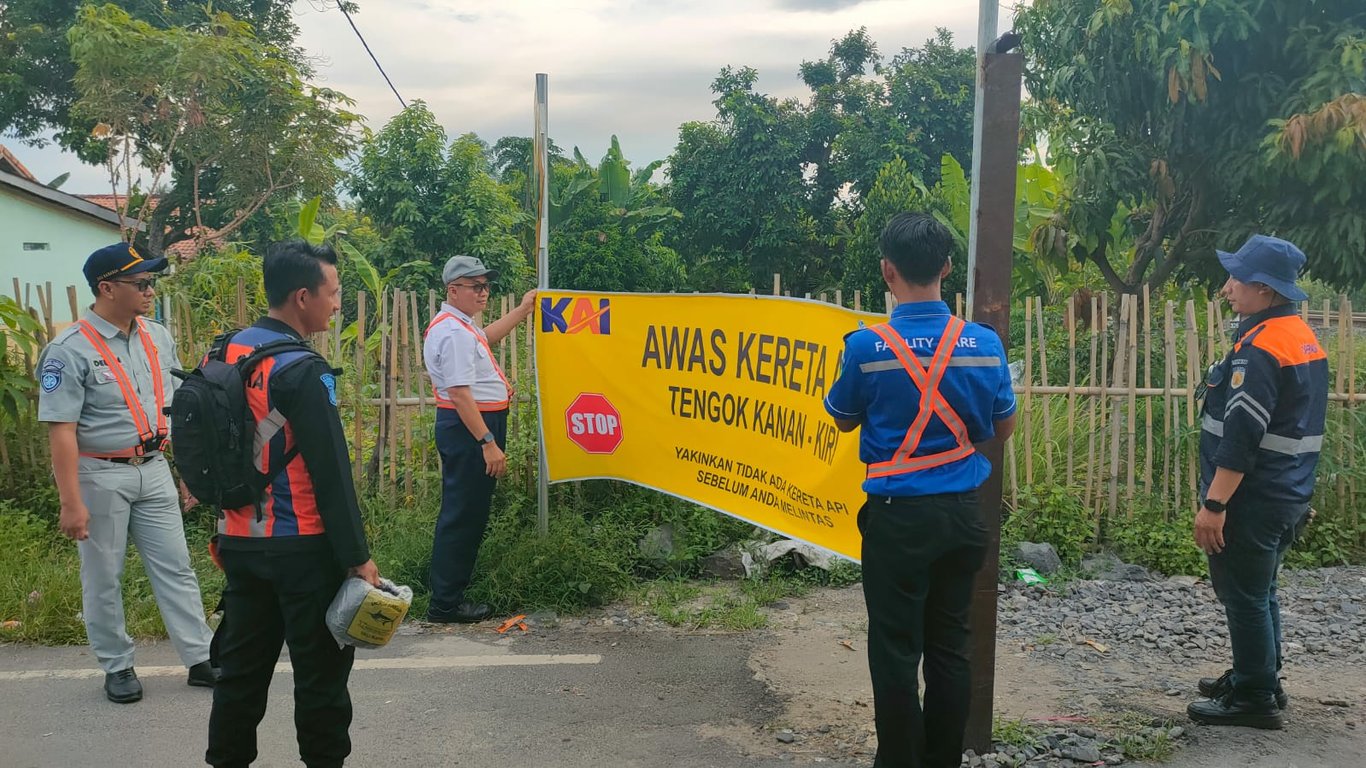Foto : Pemasangan banner peringatan untuk berhati-hati di perlintasan sebidang