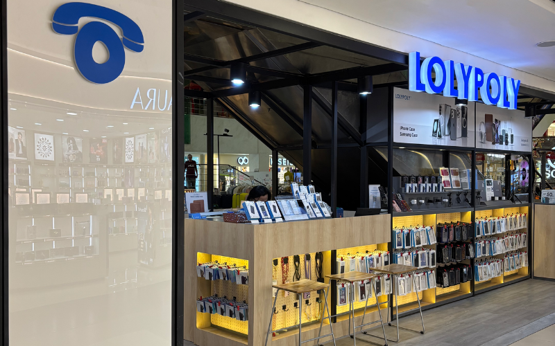 Area front counter dilengkapi dengan light box branding, serta rak-rak produk yang tertata rapi dan fungsional. Interior minimalis dengan visual yang kuat turut menunjang experience berbelanja.
