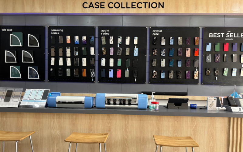 Salah satu highlight-nya adalah area Case Collection Wall, tempat menampilkan berbagai koleksi casing dengan sistem display modular. Di area kasir, terdapat meja custom dengan lighting bawah yang memberikan kesan modern.