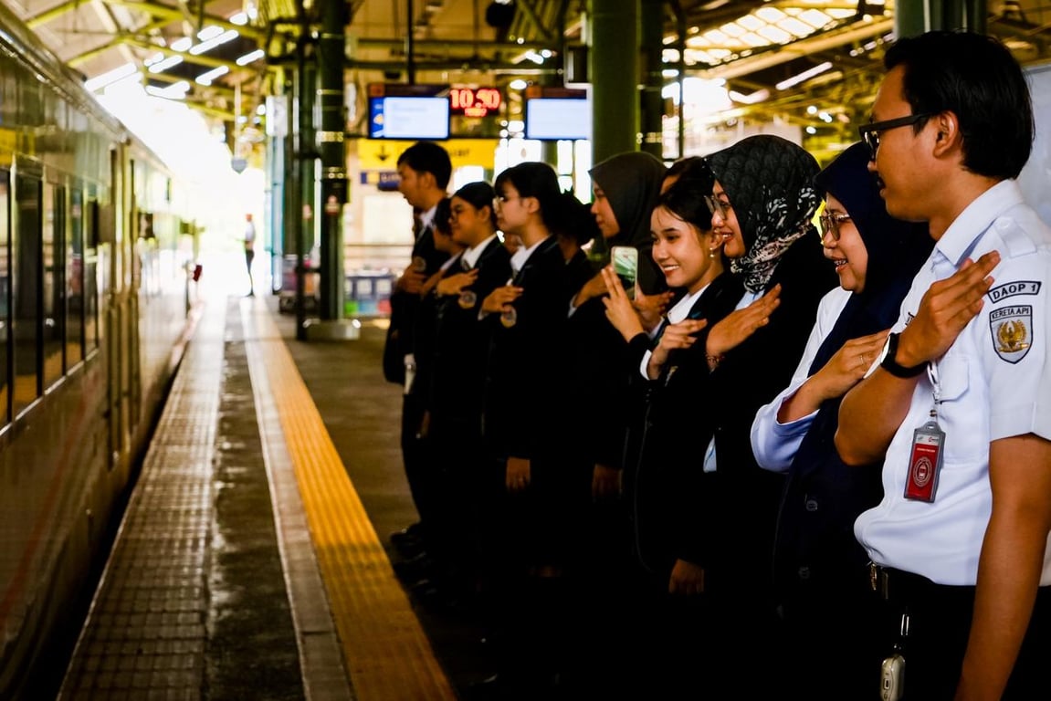 Para siswa SMK Jayawisata 1 melakukan salam penghormatan kepada pelanggan kereta api di Stasiun Gambir