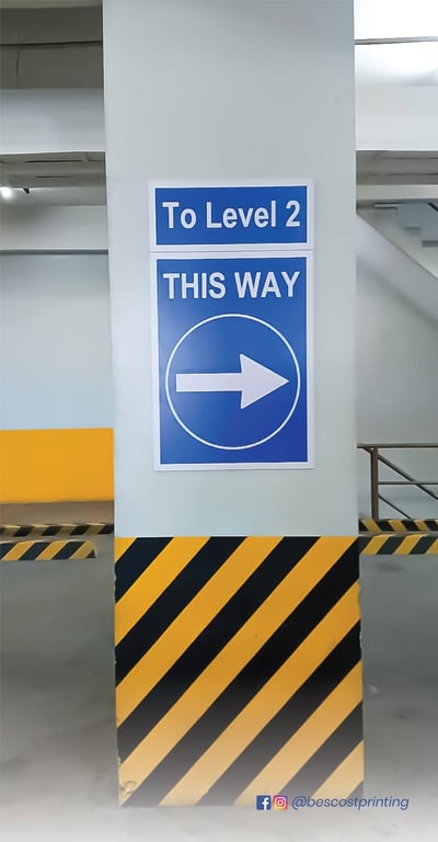Bescost Printing | Clear, high-visibility directional sign guiding vehicles to the next level in a parking facility.