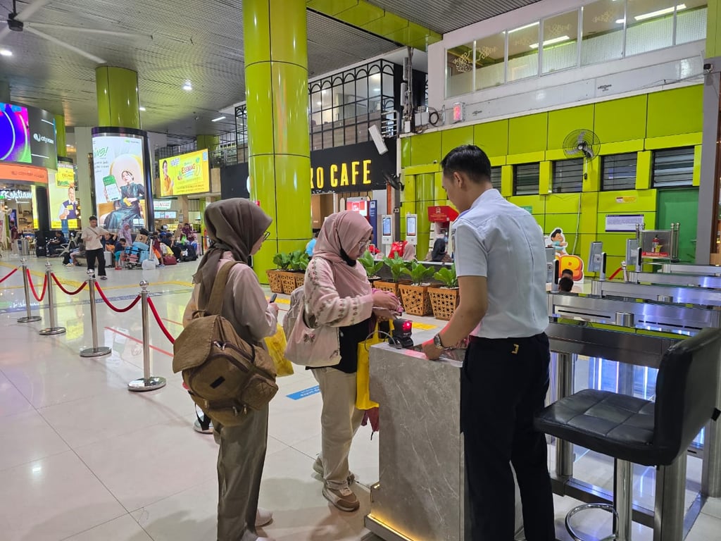 Penumpang kereta saat melakukan boarding pass di Stasiun Gambir
