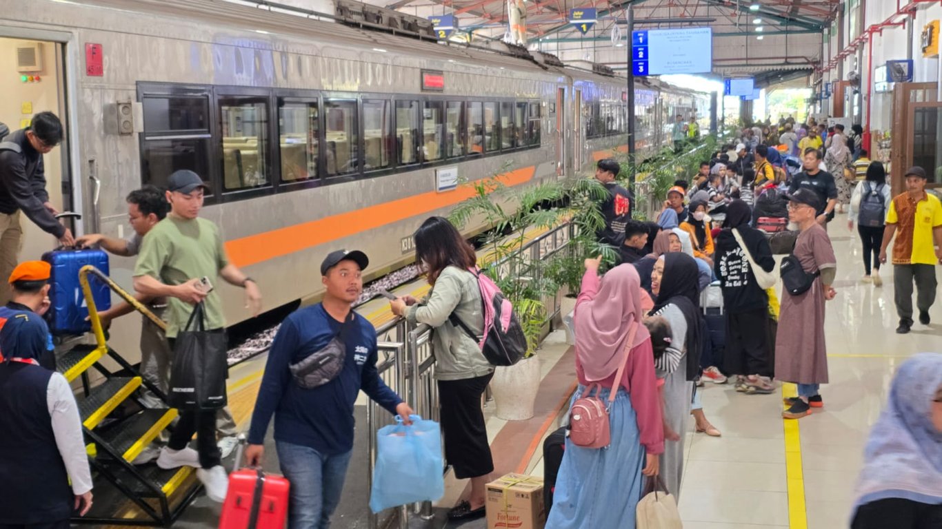 Tampak Penumpang sedang naik dan turun dari KA Jarak Jauh di Stasiun Madiun
