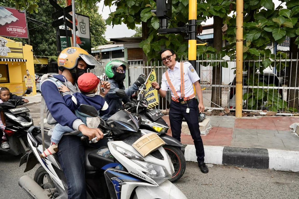Salah satu pegawai KAI mengajak pengendara sepeda motor untuk terus berdisplin tertib lalu lintas