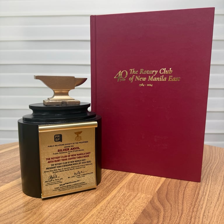 The Silver Anvil Award rests beside 40 Years: The Rotary Club of New Manila East (1984–2024)—a quiet but powerful reminder of four decades of service, shared purpose, and lives changed through Rotary.