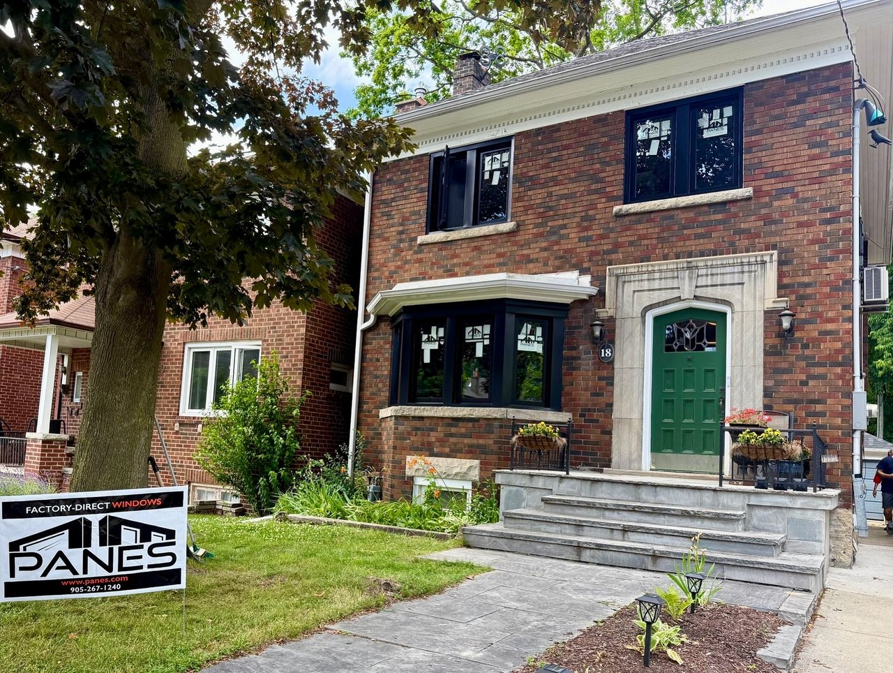 Black-framed Panes replacement windows on the upper and ground floors of a Toronto red-brick home