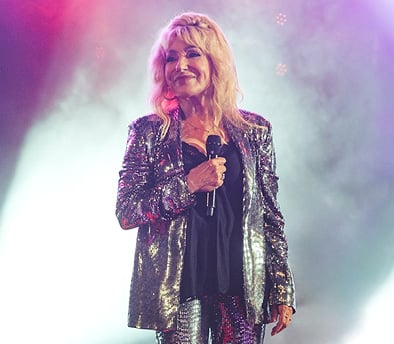 תמונה של ריקי גל על במה אוחזת במיקרופון מחוייכת