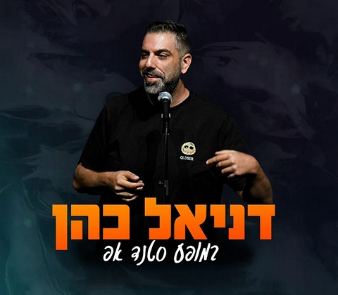דניאל כהן עומד מול מיקרופון מחוייך