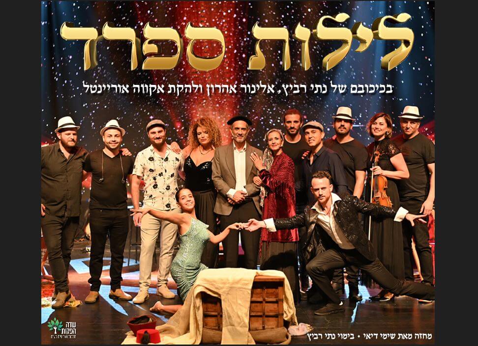 13 שחקני המחזמר במנחים שונים. חלקם חובשים כובעים. שחקנית אחת אוחזת בכינור בידה. ברקע התפאורה של ההצגה