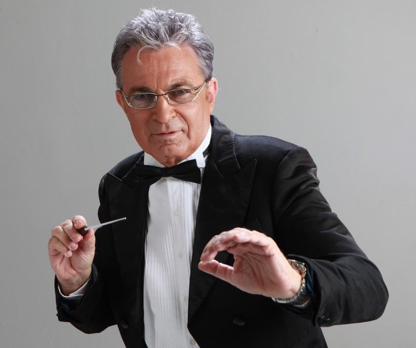 ננסי ברנדס לבוש חליפה עם פפיון מחזיק מקל מנצח