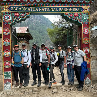 A group of 8 trekkers are posing in front of the Sagarmatha National Park in Nepal